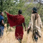 A tourist takes a Tanzania safari with a Maasai guide on the savannas of the Serengeti