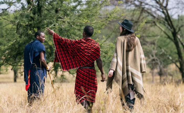 A tourist takes a Tanzania safari with a Maasai guide on the savannas of the Serengeti