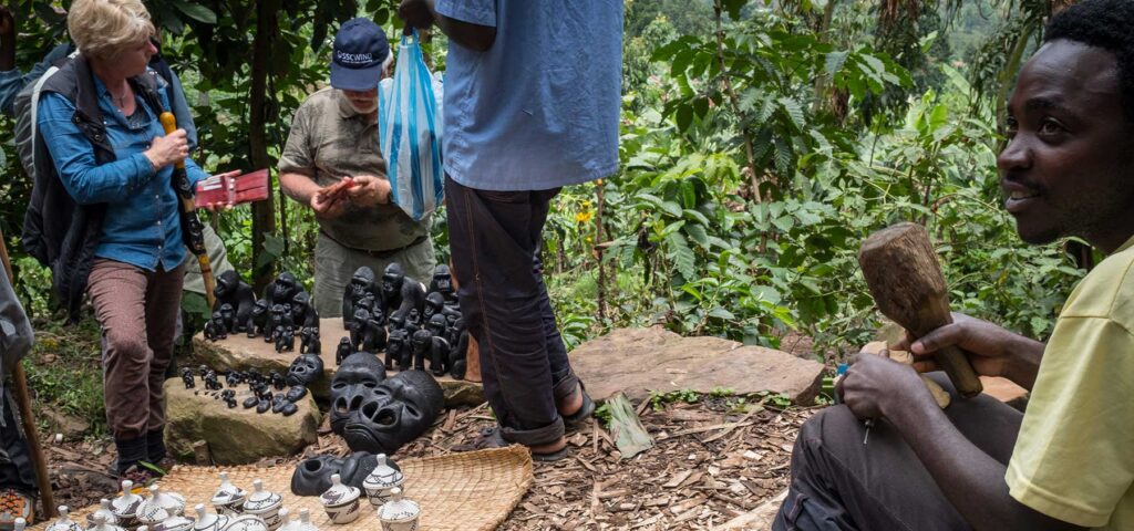 Tourists after a gorilla tracking tour considering local handicrafts produced and sold along the trails in and out of Bwindi Impenetrable National Park, Uganda- Nandi Adventures (a Travelife Partner tour operator). Photograph by Jason Houston